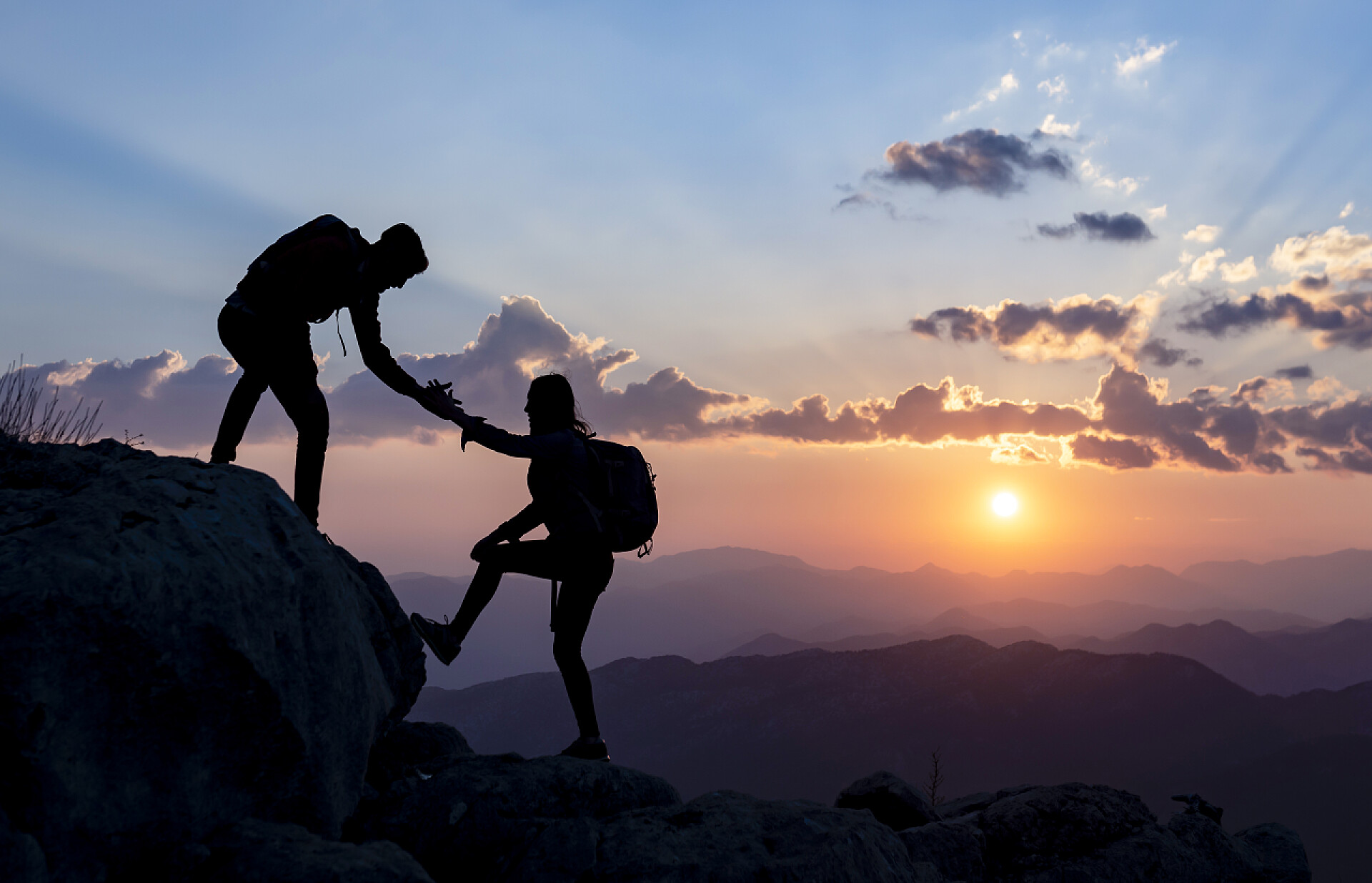 蓝天白云下两名登山运动者的剪影户外活动