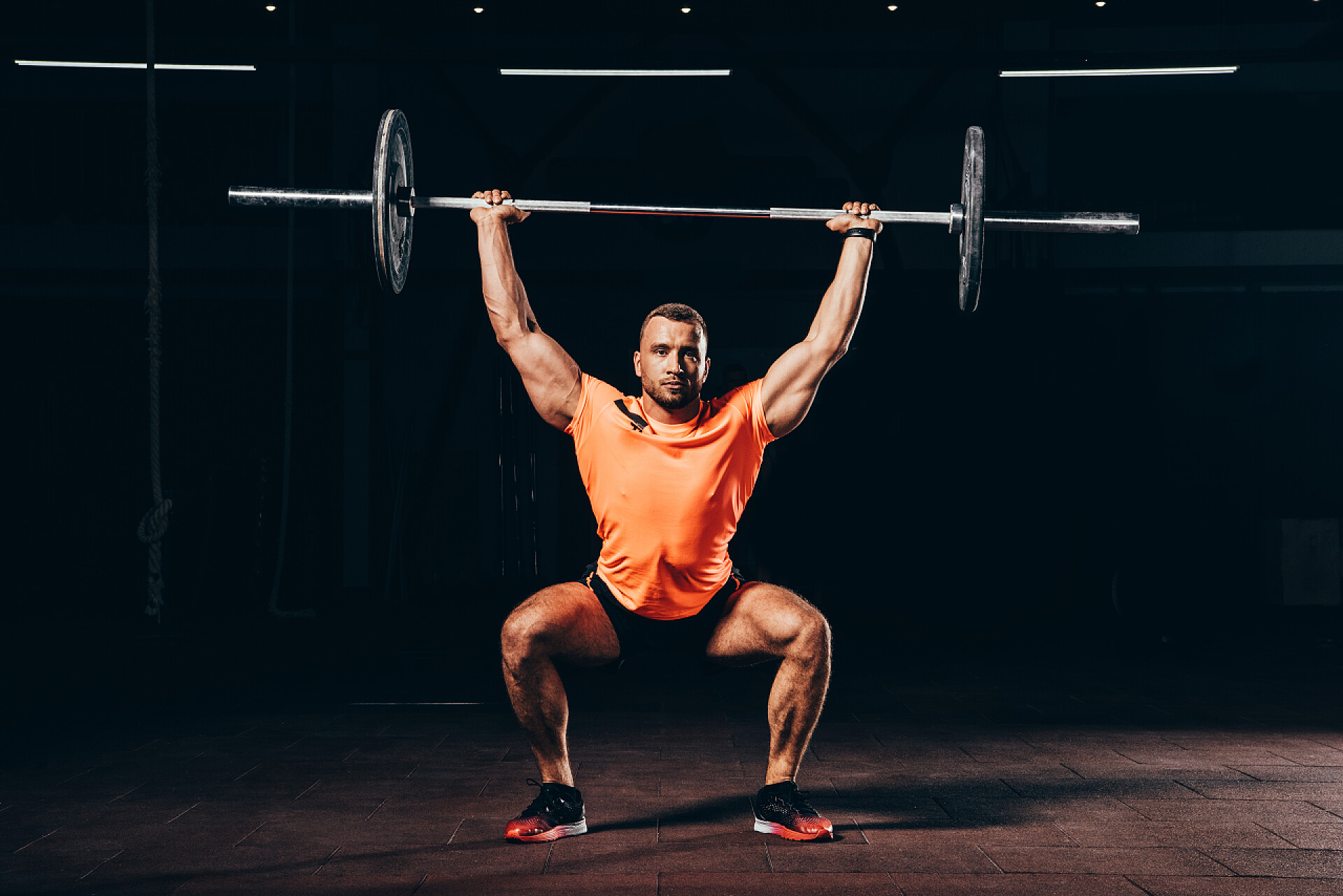 黑色背景健身房里正在举重的运动员体育运动锻炼