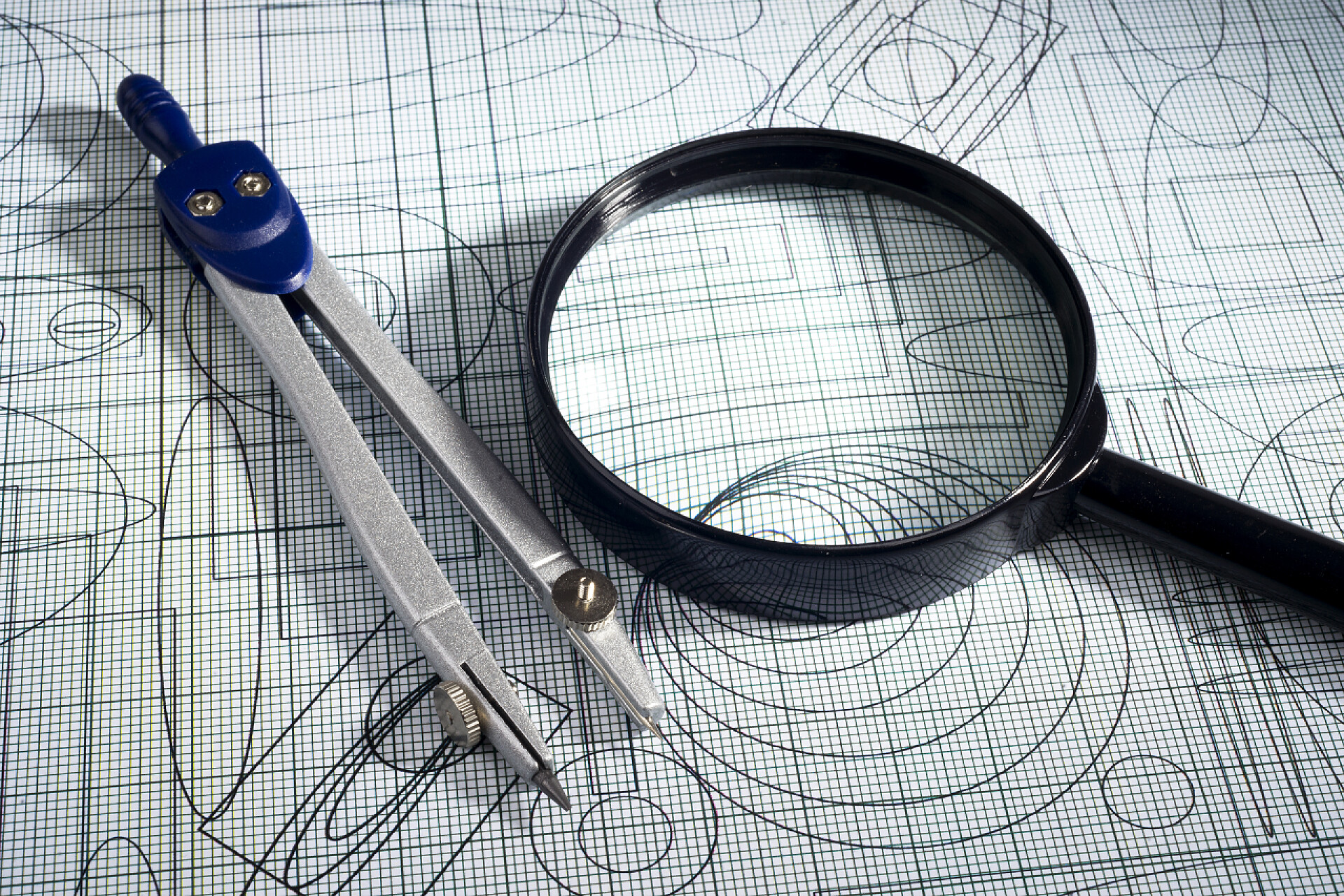 图纸上放大镜和圆规特写