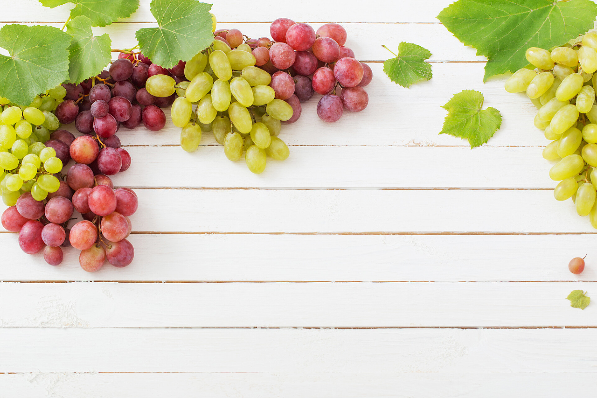 木质背景上粉红色和绿色的葡萄水果