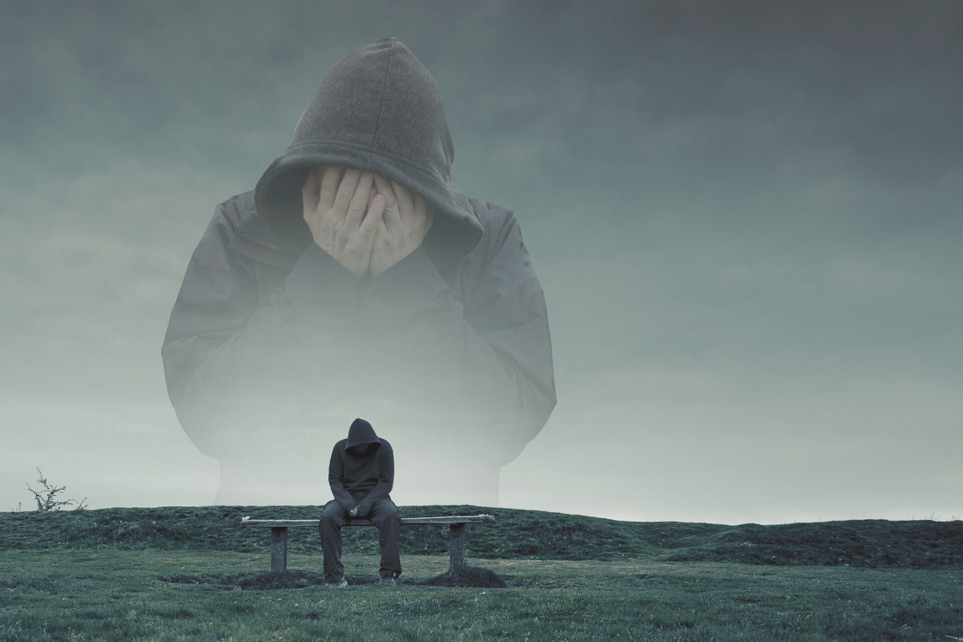 一个男人沮丧的坐在公园的长椅上