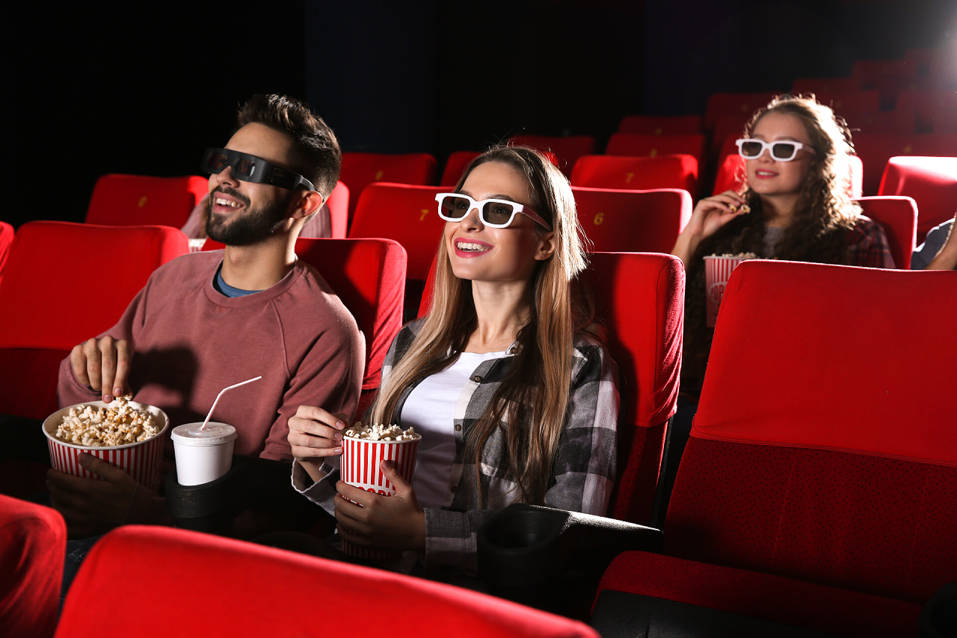 一对情侣在电影院吃爆米花看电影休闲娱乐