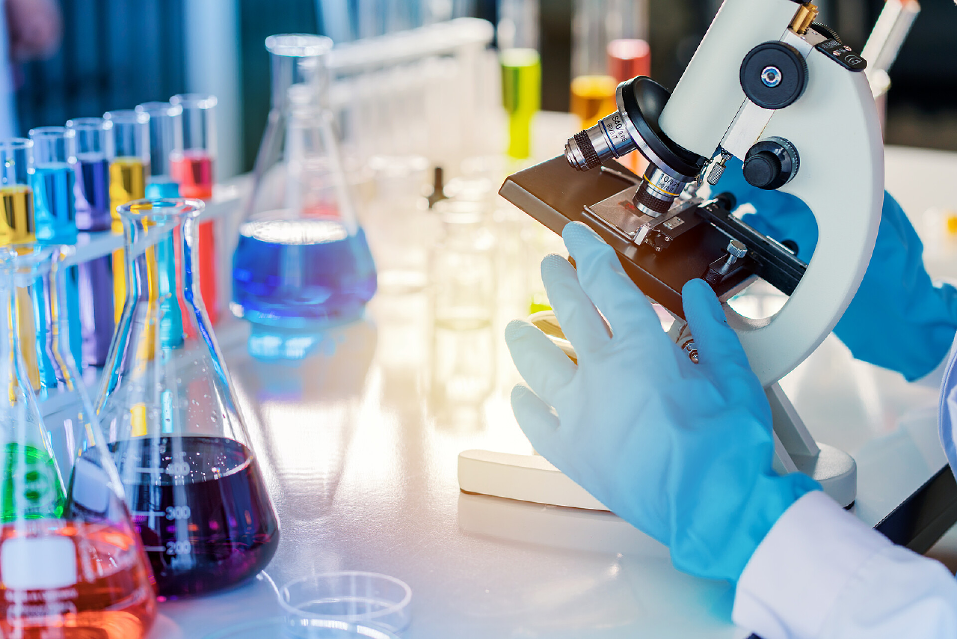 科学家研究者使用显微镜观察玻璃器皿