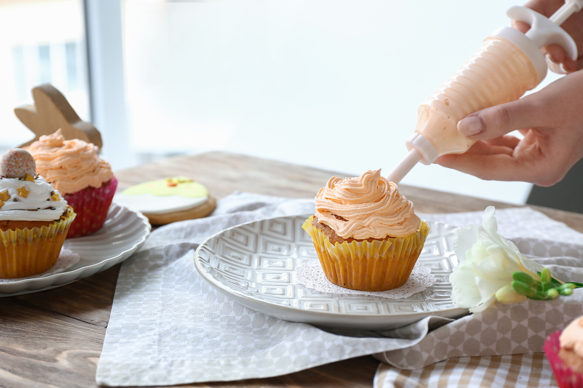 准备美味的复活节纸杯蛋糕在厨房的妇女