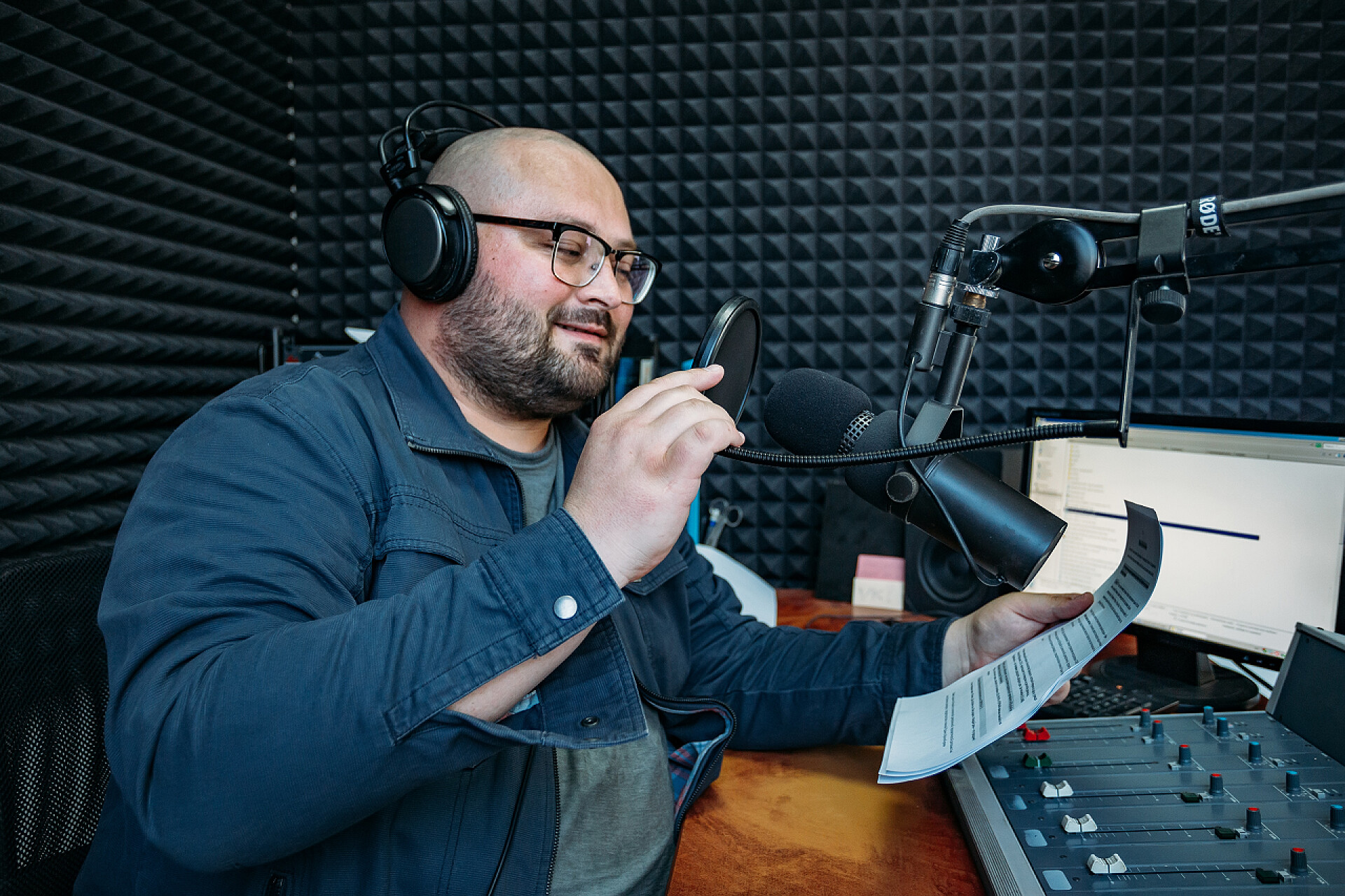 微笑的男性电台主持人在电台阅读稿件