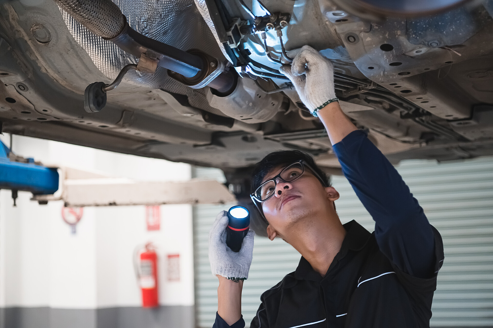 汽修人员对车底进行检查