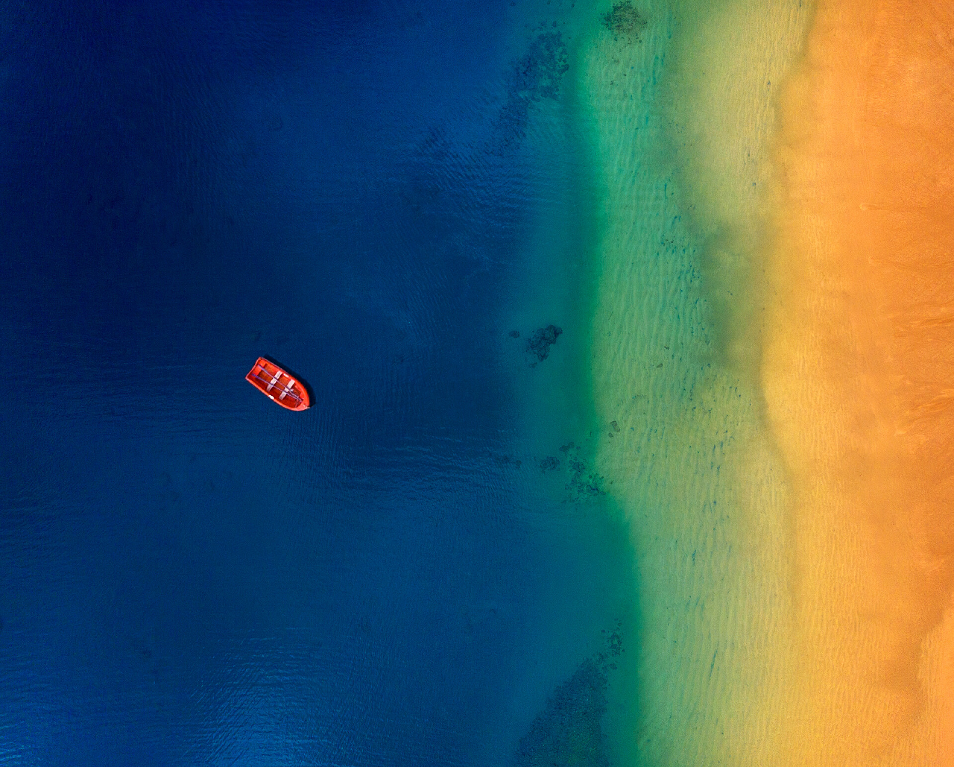 海滩外停泊的一艘孤独红船