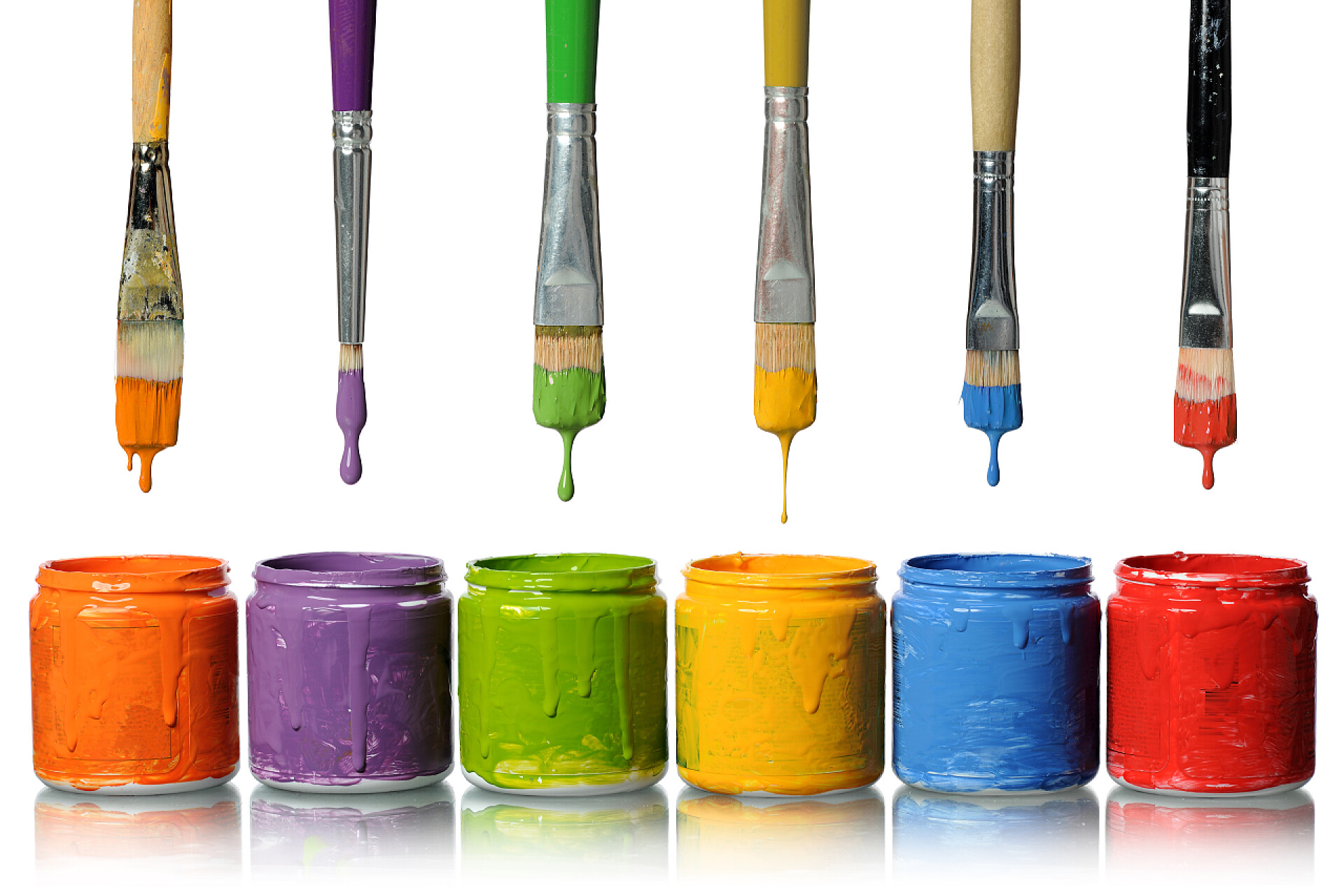 在白色背景上的各种油漆刷排列整齐竖立滴入油漆瓶里