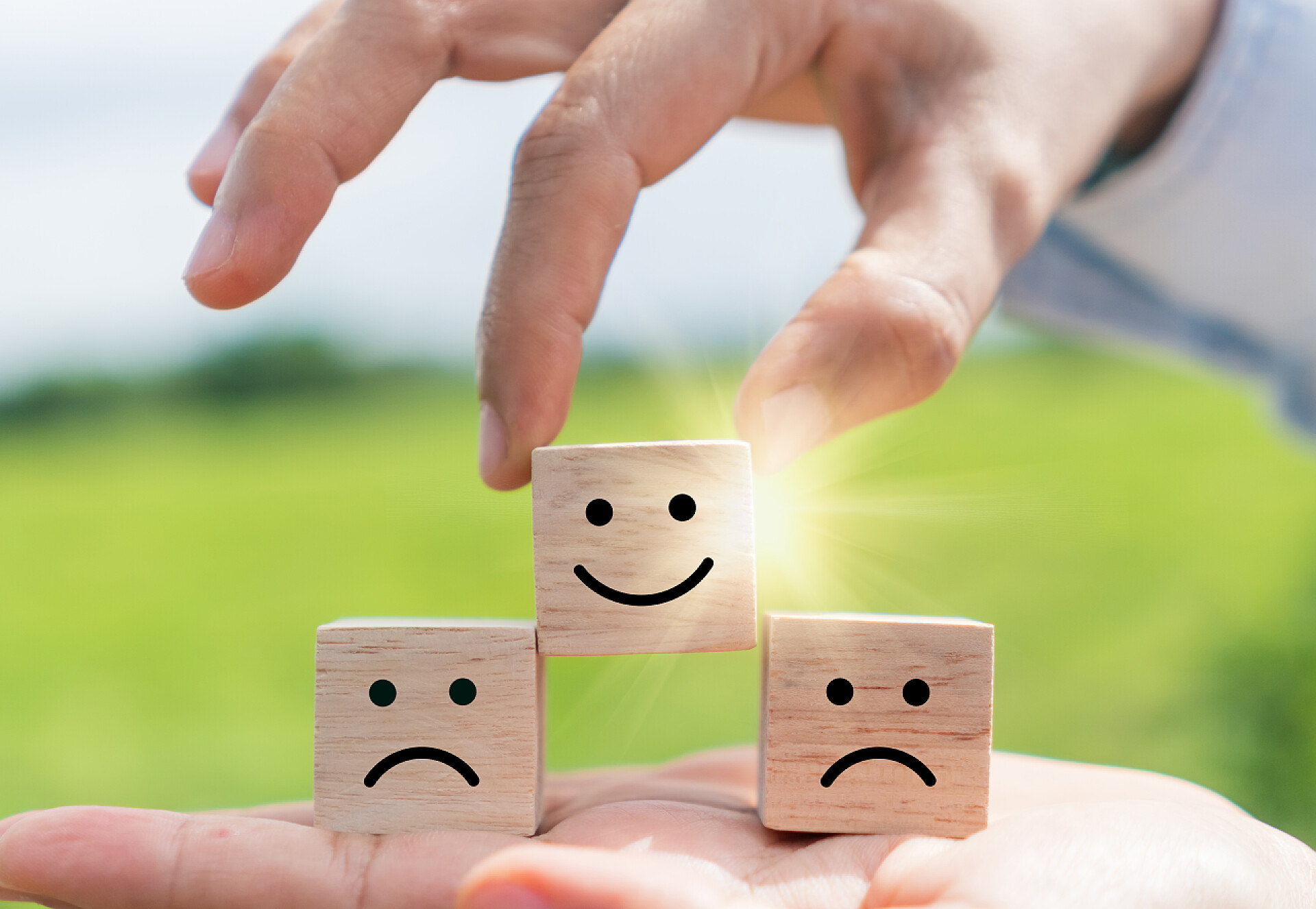 一只手把木制立方体上的笑脸挑出来