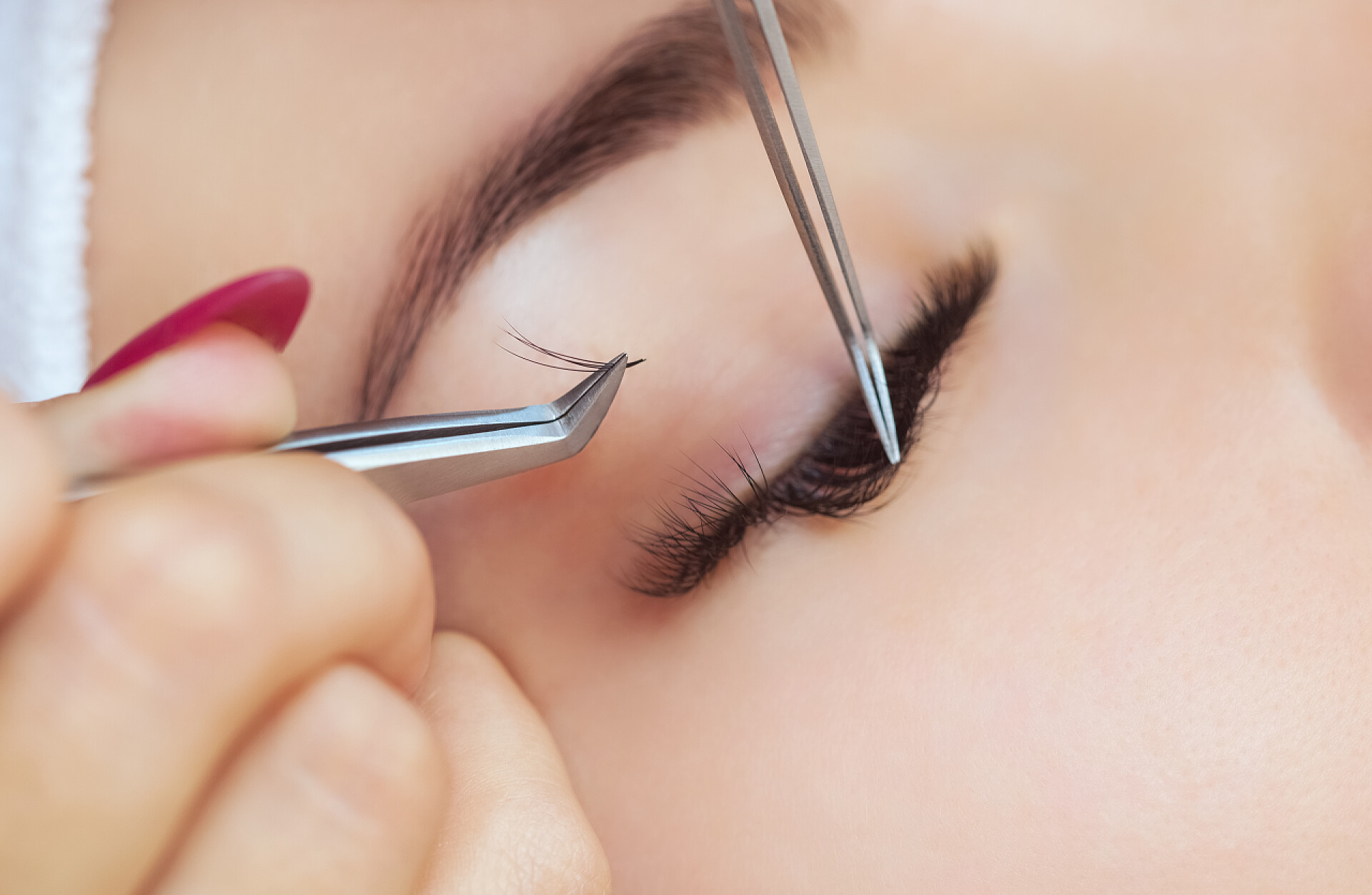 美丽的女人在美容院里植入睫毛医疗美容