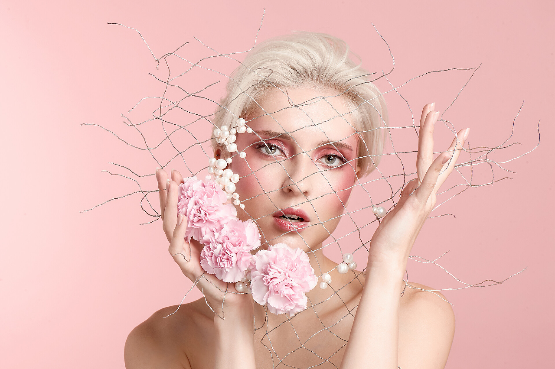 粉色背景上手拿鲜花和网格的美女人物生活美肤美妆化妆品模特写真