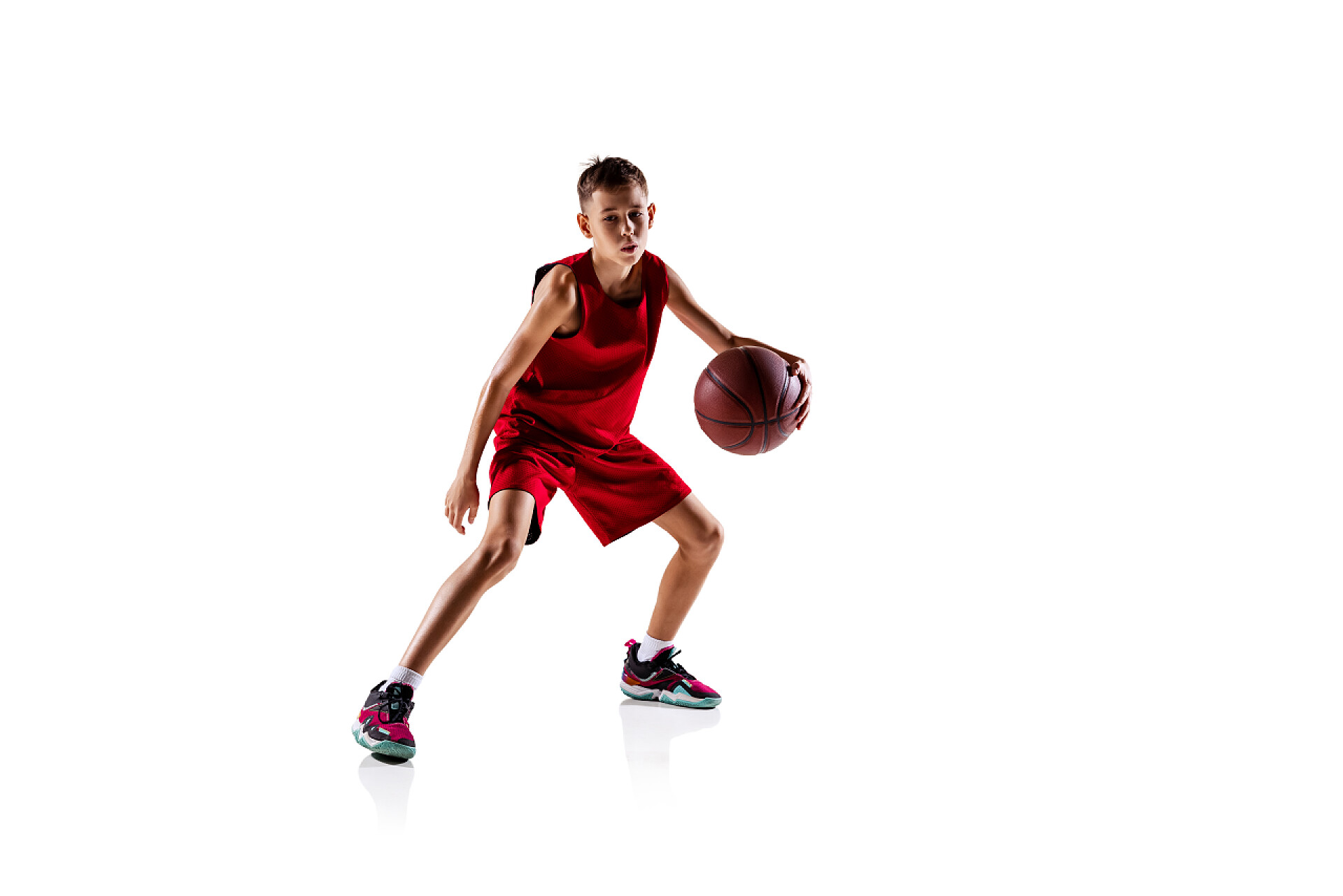 白色背景上打篮球的运动员体育运动,身穿红色制服训练的篮球运动员被隔离在白色背景之外.流口水练习。动机、运动、行动、运动、健康的概念。广告的复制空间