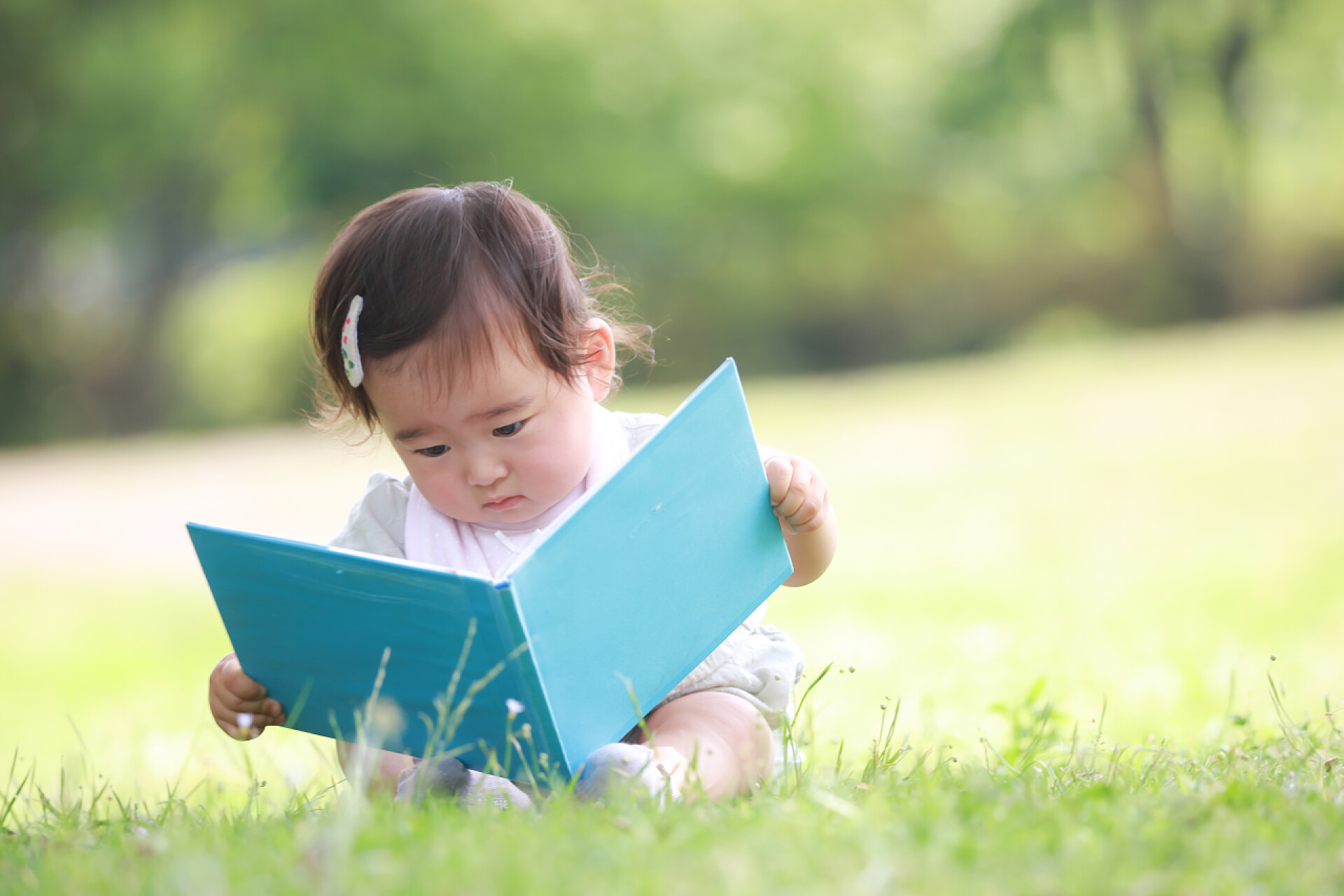 坐在草坪上看书的小女孩人物生活
