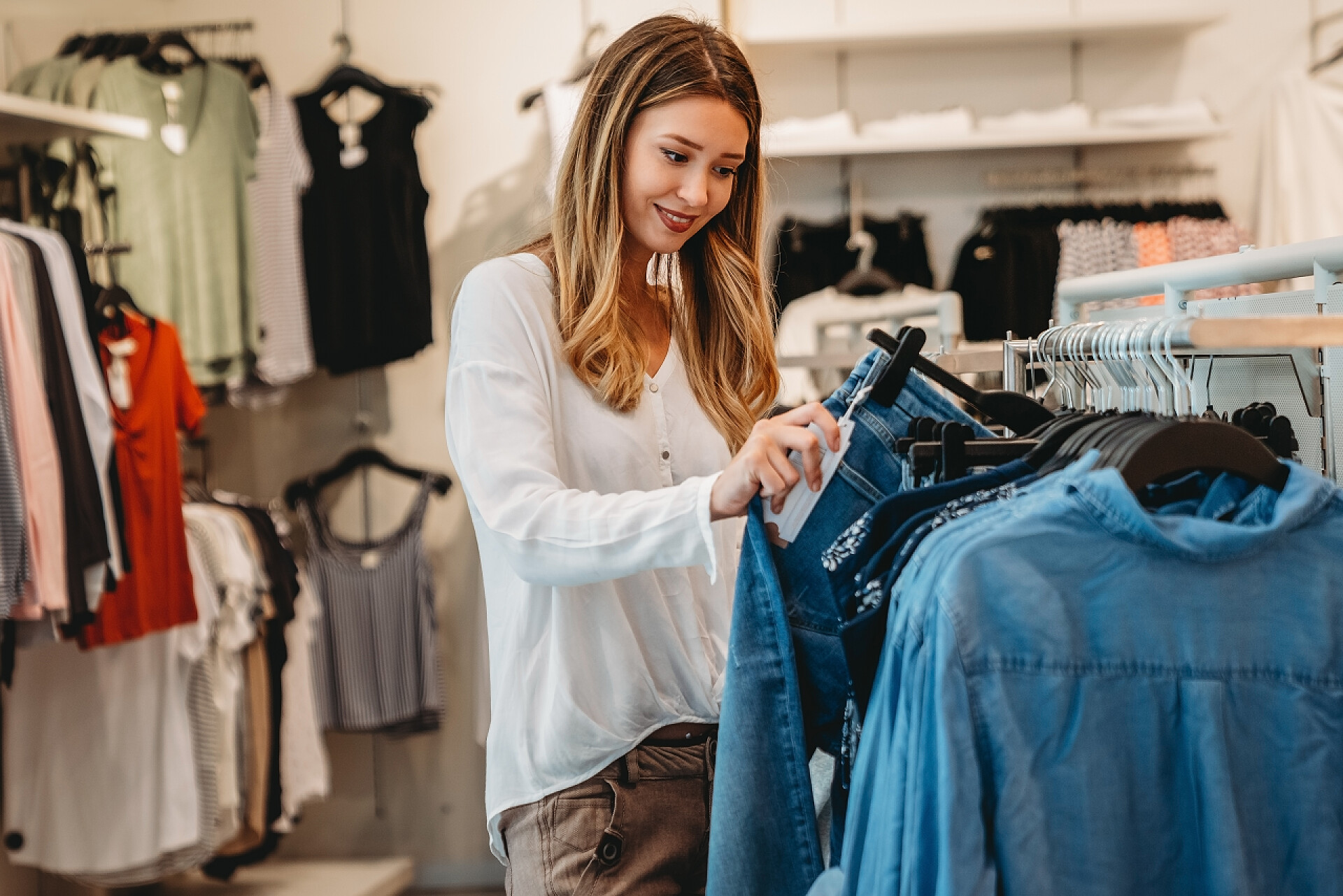 一个年轻美丽的女人在服装店里挑选衣服的场景逛商场