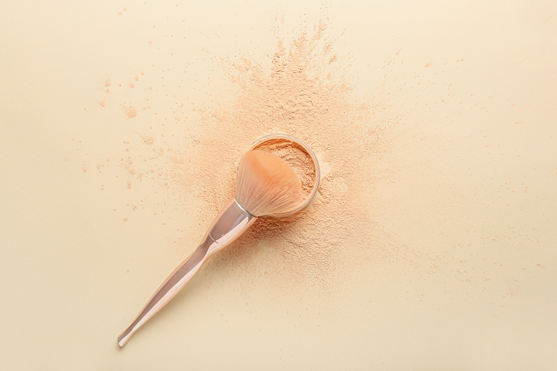 浅色背景下的化妆刷和松散粉美妆