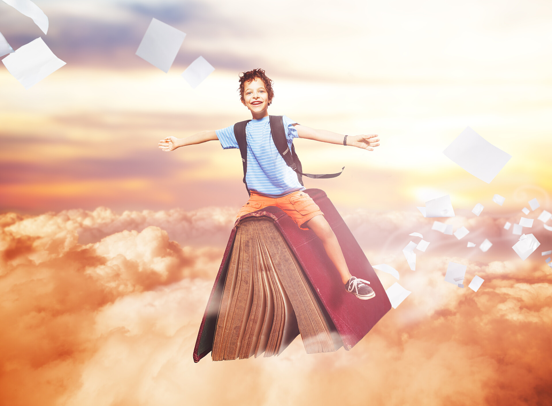 儿童节61儿童节人像梦想憧憬展望未来儿童快乐的小男孩驾驶着书本在云层张开手臂的形象