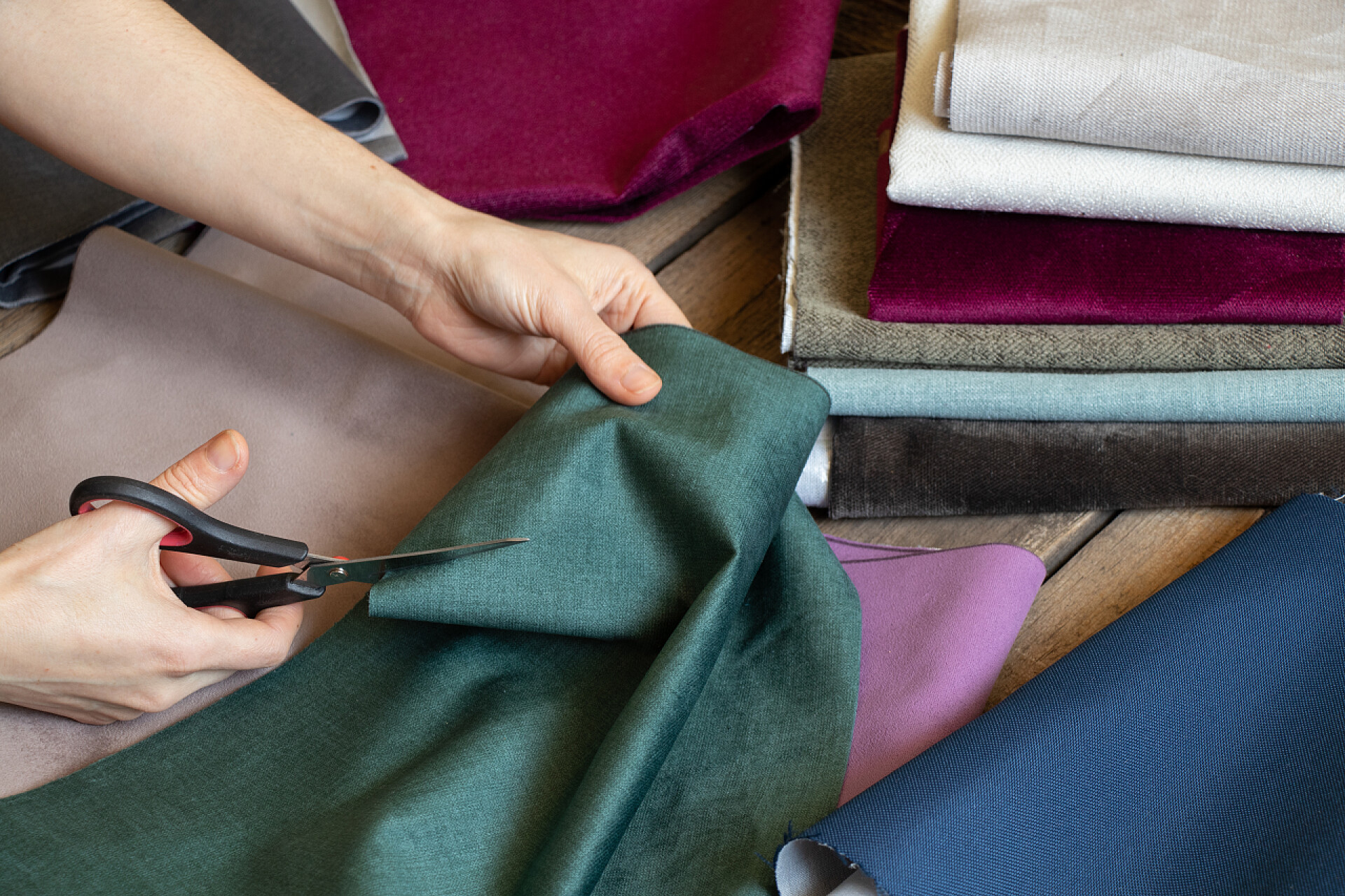 女性的手在桌上裁剪不同的面料