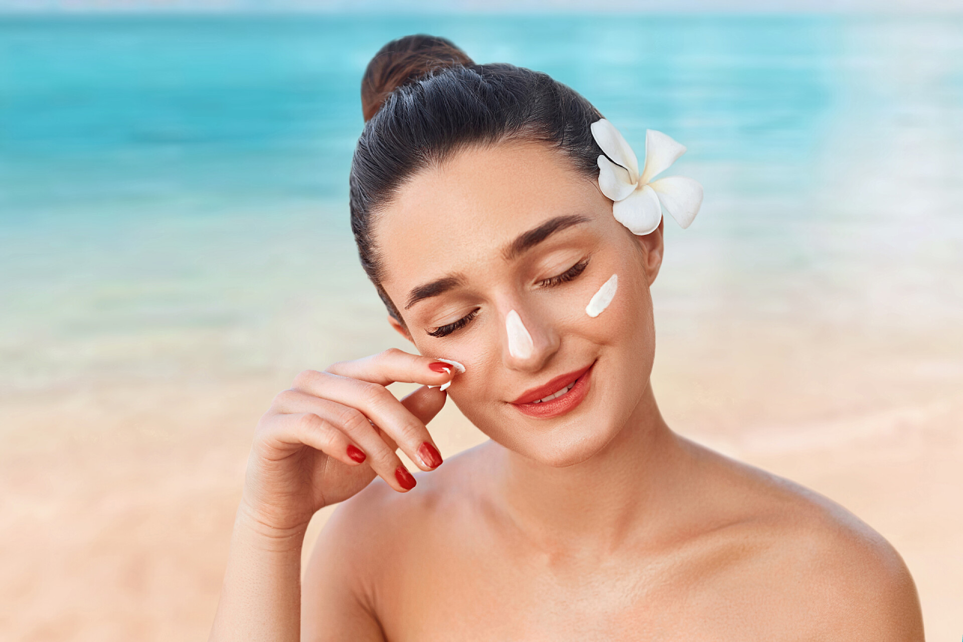 漂亮的年轻女人脸上涂满了防晒霜美肤美容