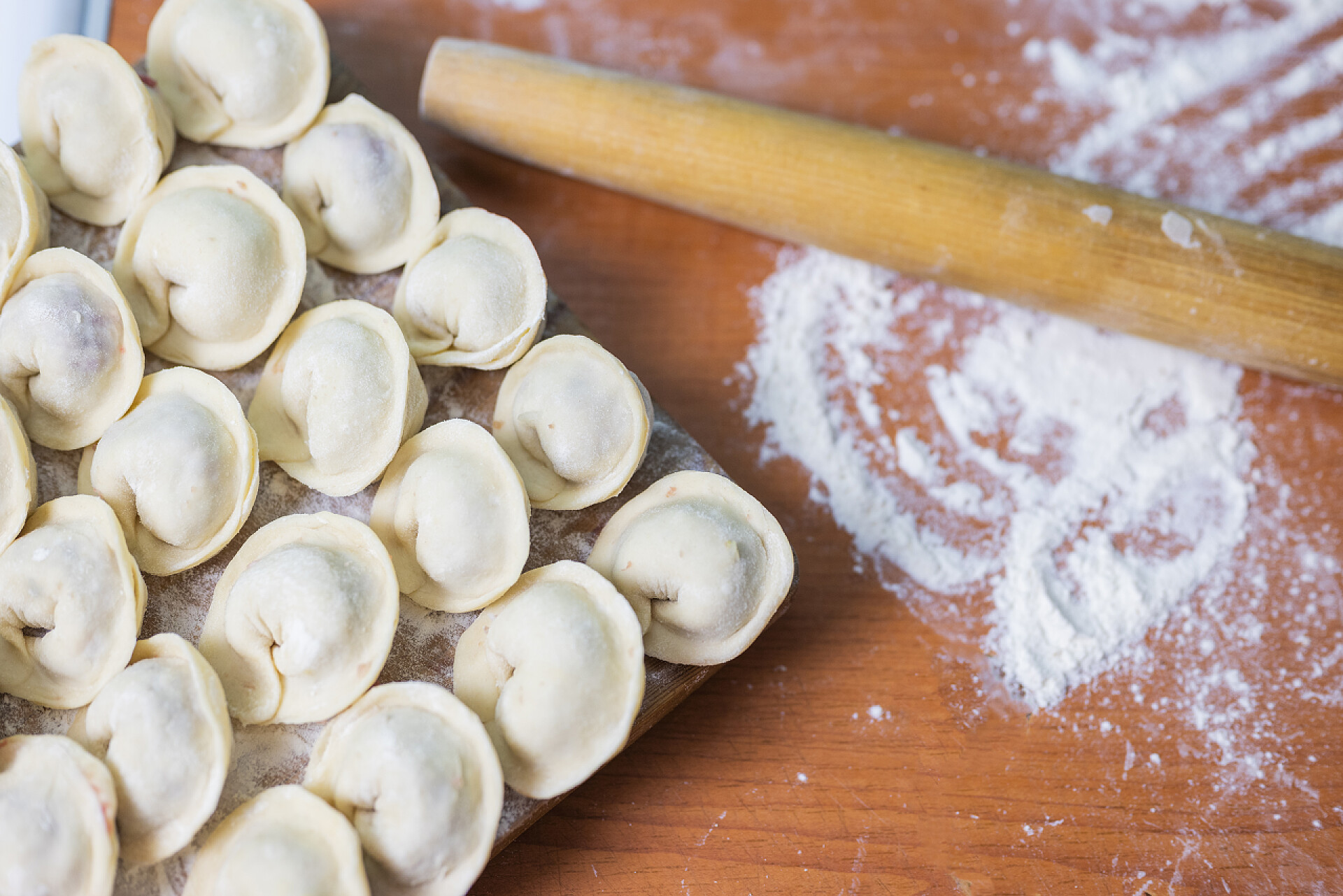 案板上的面粉擀面杖和生的饺子过节团圆团聚