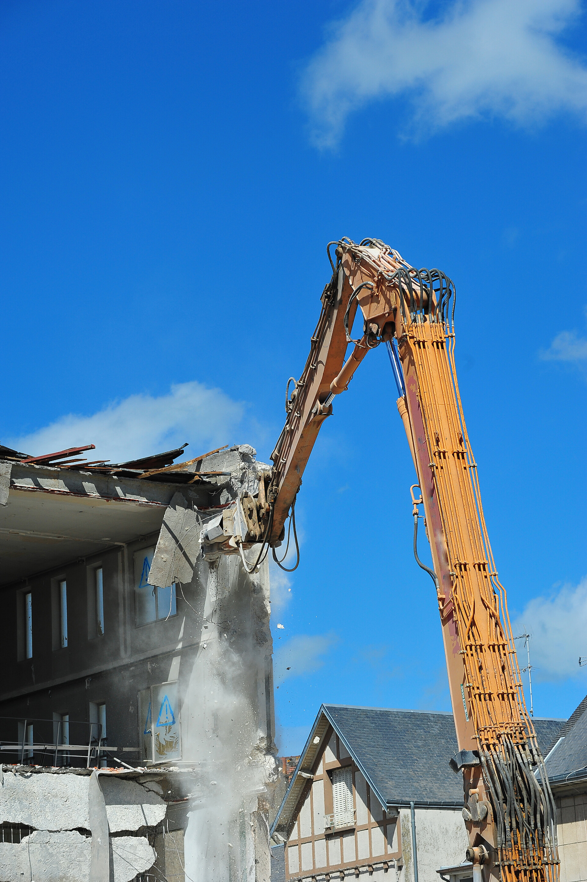 蓝色天空下拆除房子的挖掘机房屋拆迁