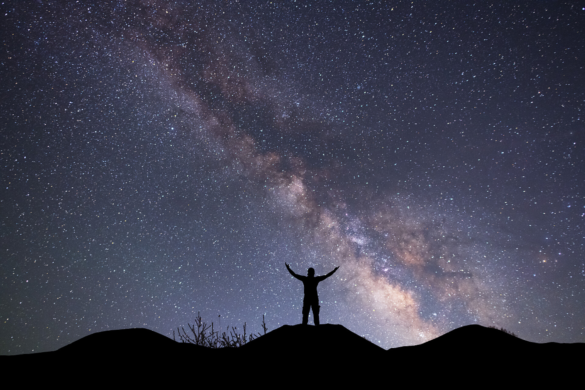 站在山顶上欣赏夜空的人