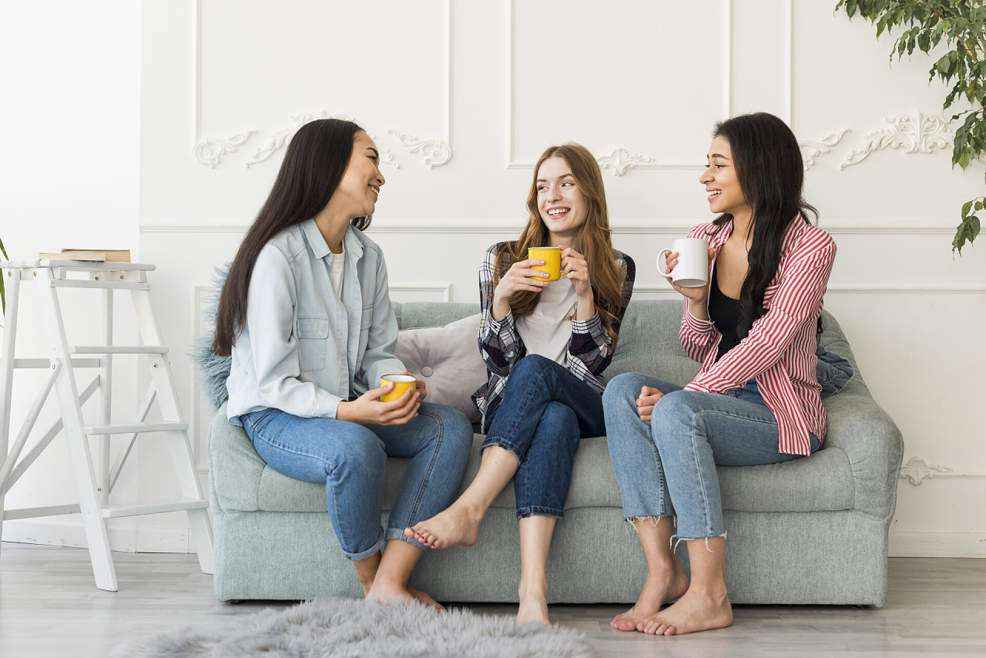 女人手拿杯子坐在沙发上聊天