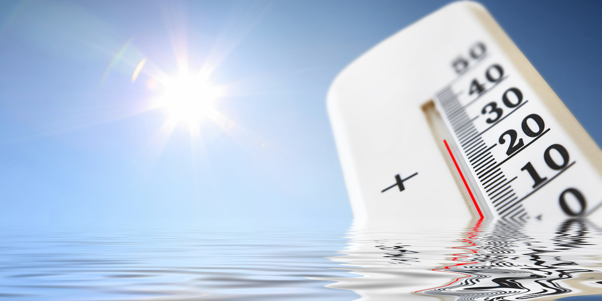 蓝天下水面上的温度计