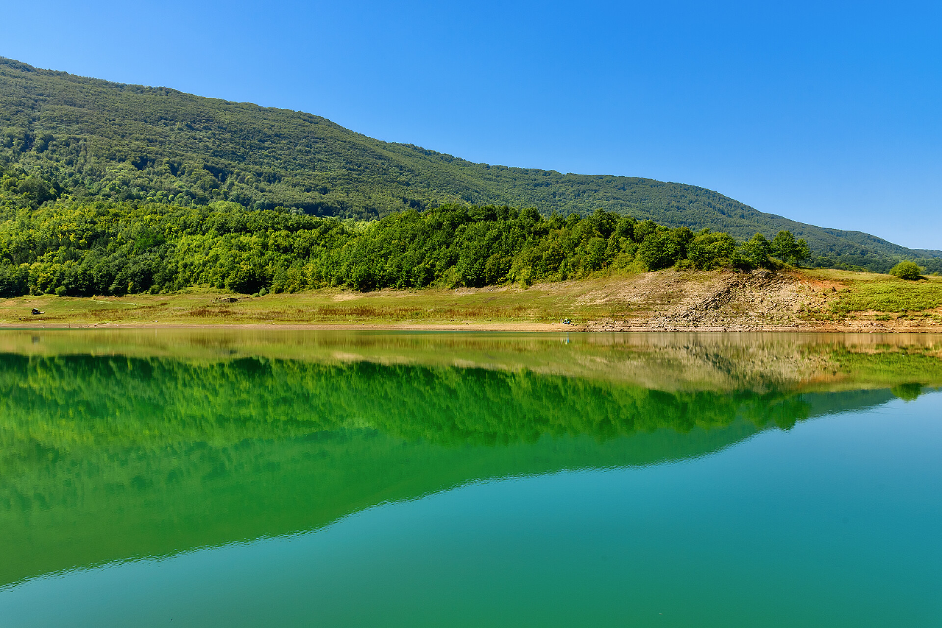 绿山倒映在清澈湖中的美景图