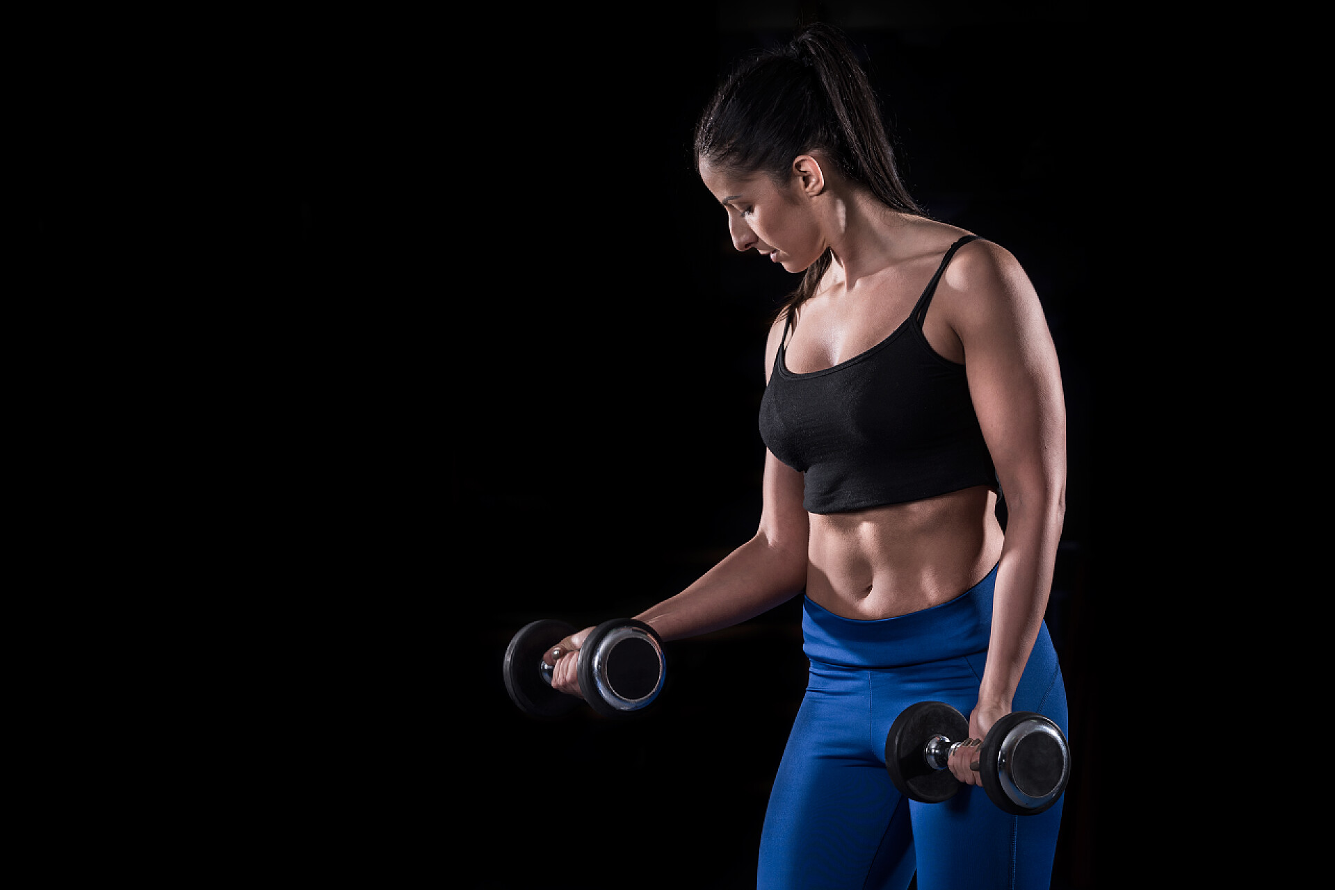 体育运动锻炼黑色背景上举铁的女孩健身房撸铁