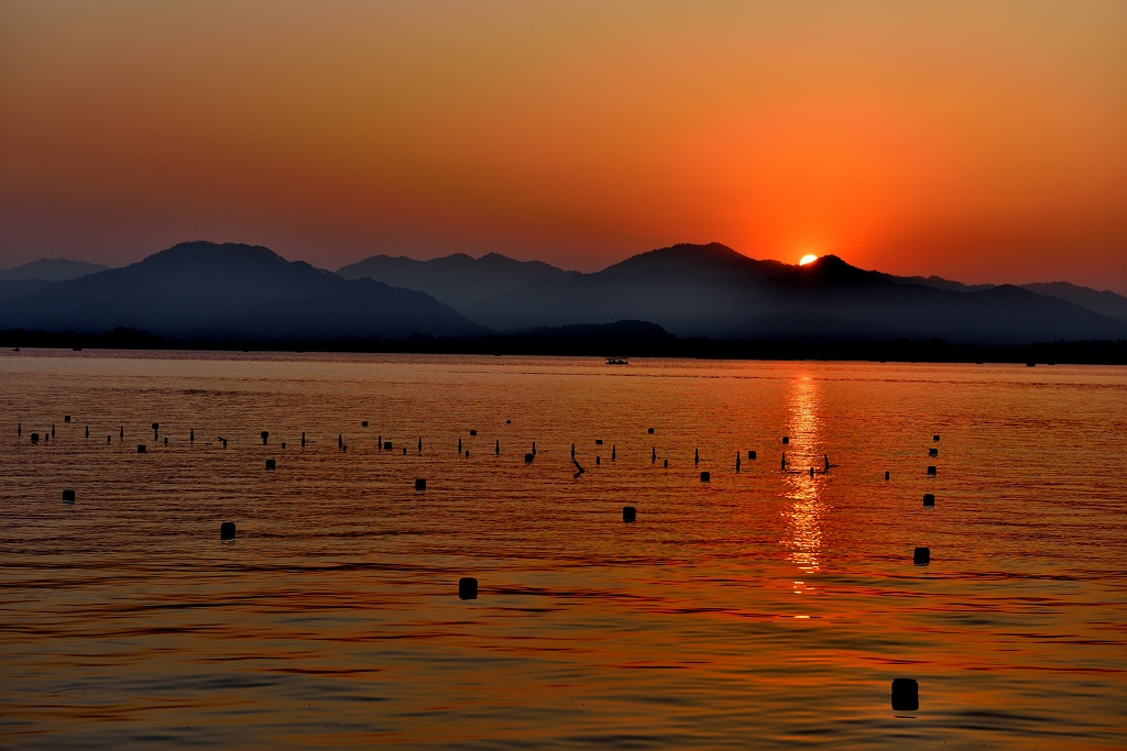 晚霞染红了西湖湖面山岭的剪影