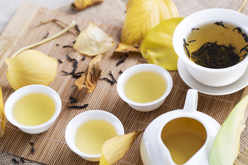 桌上放着白茶杯和秋叶。秋茶。