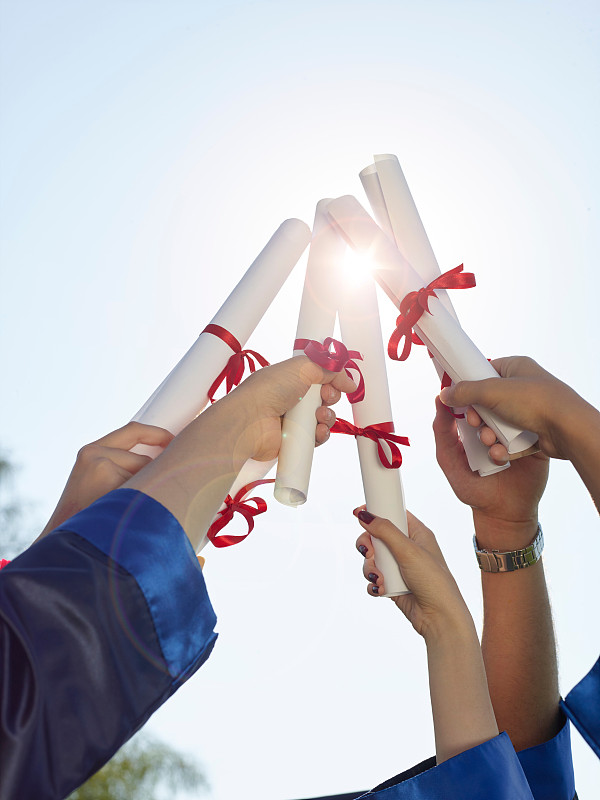 一群大学毕业生举着文凭在空中