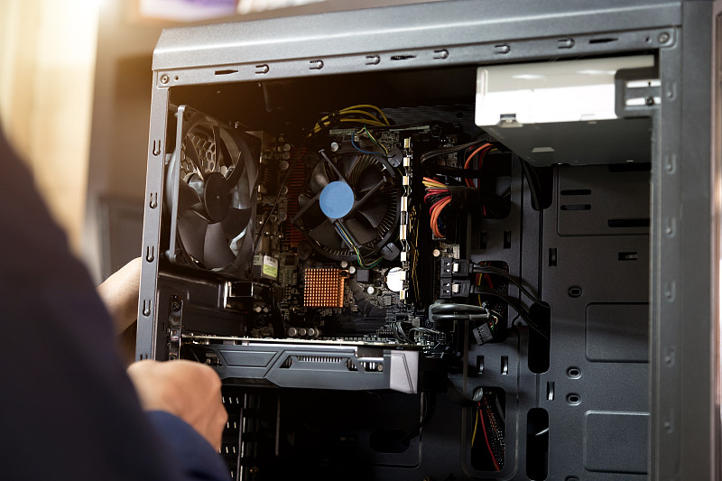 用螺丝刀修理电脑的技术员，电脑