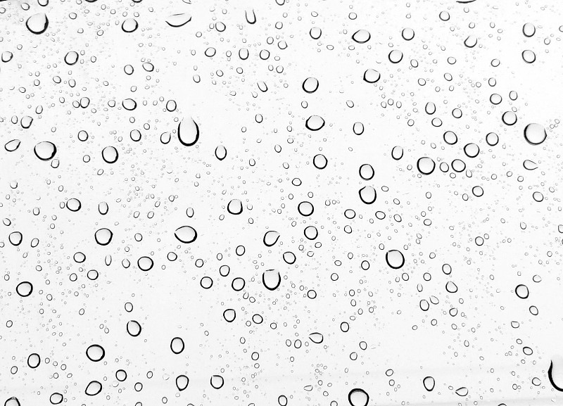 雨滴落在窗户玻璃上，白色的背景