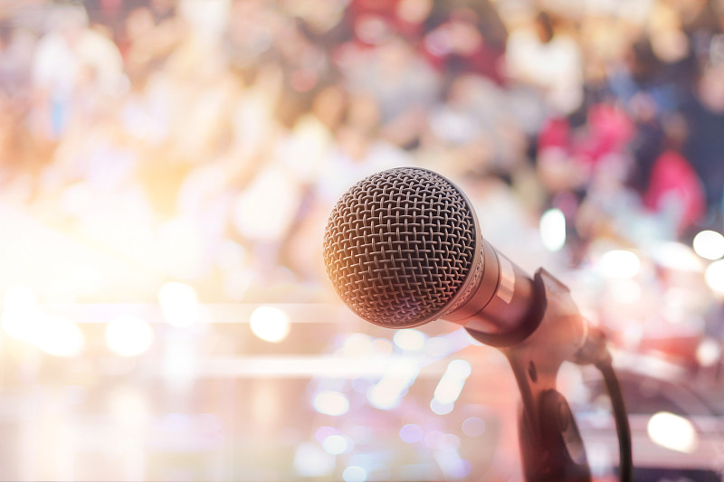 舞台上的麦克风以人为背景