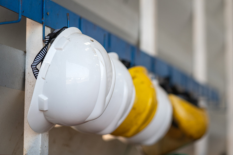 黄色和白色的安全帽，保持在架子上。