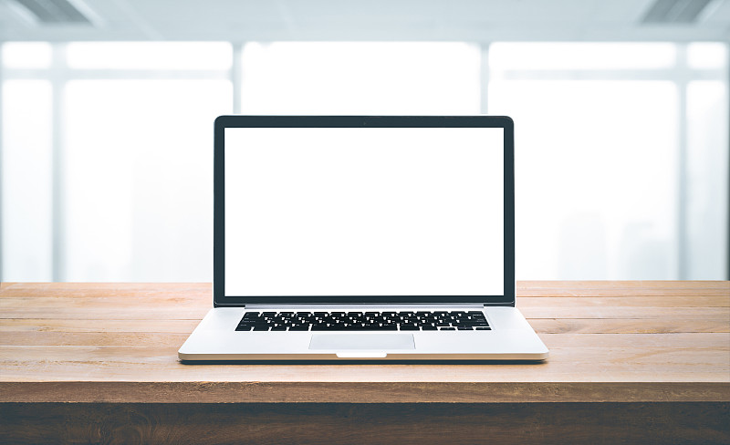 电脑，带空白屏幕的笔记本电脑，放在带办公室的木桌上