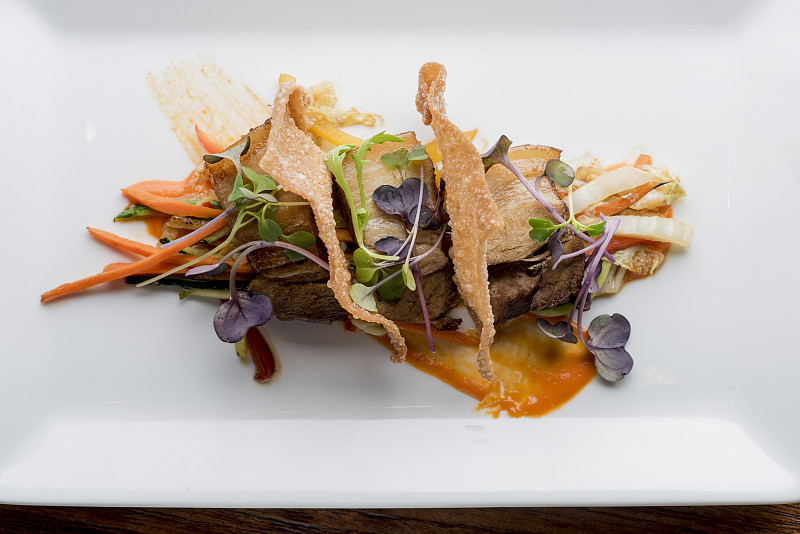 五花肉开胃菜。经典的美国餐厅最爱:炸五花肉配酱，腌胡萝卜，新鲜黄瓜jalapeños和香菜在黄油烤法棍面包上。