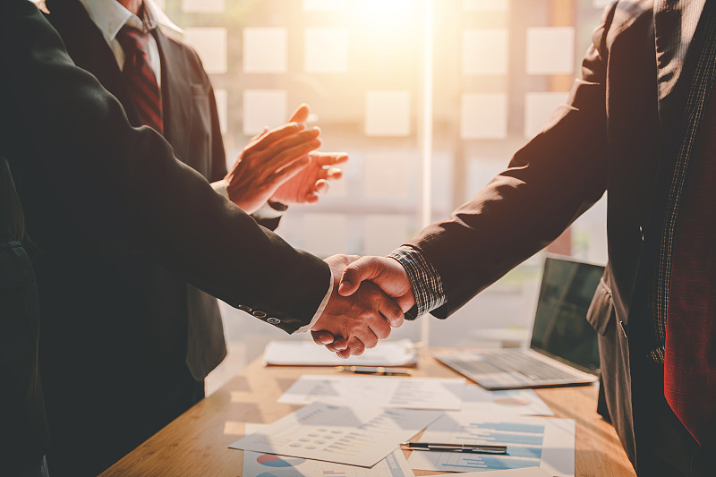 商务伙伴握手概念同事握手在一次伟大的会议后成功成交。模糊的背景。