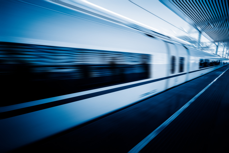 高速列车停靠在火车站，动作模糊。