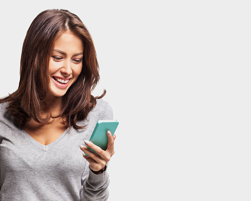 快乐的年轻女孩使用智能手机