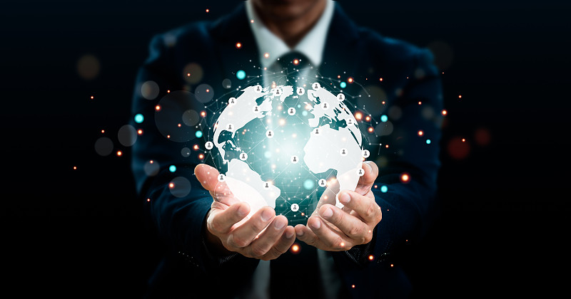 一个商人持有“连接全球网络”。大数据分析和商业智能。全球业务点和线组成概念在世界地图上。数字连接技术。