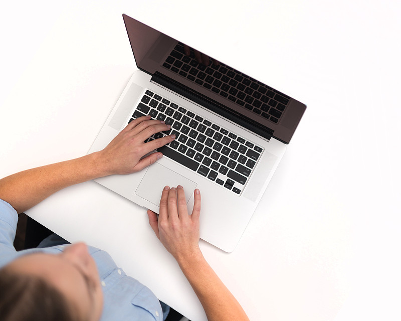 一个女人在白色背景下使用笔记本电脑