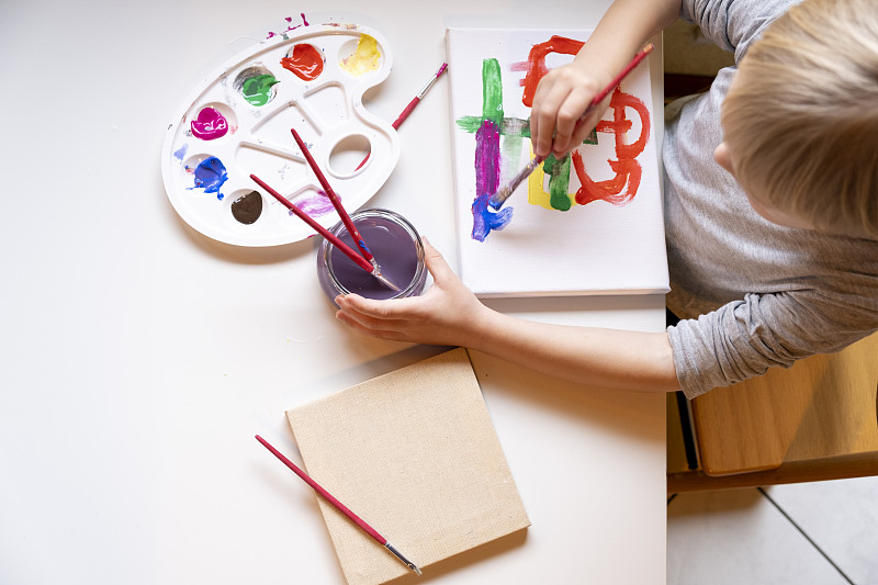 小男孩用画笔作画俯视图