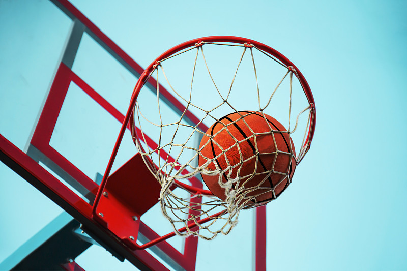 一个篮球在网里。飞球在篮筐里。一个体育游戏。