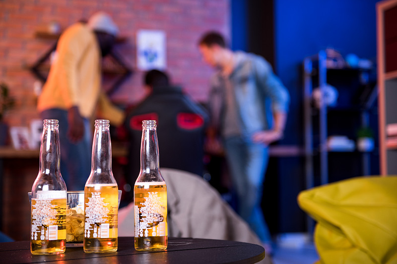 愉快的朋友在家里喝啤酒