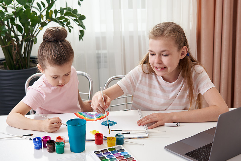 两个快乐的姐妹在家画画，彩虹画画