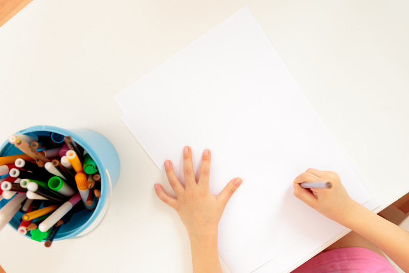 孩子的手拿着铅笔