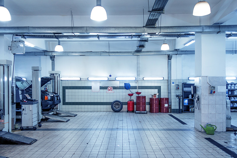 汽车修理店与机修工在背景