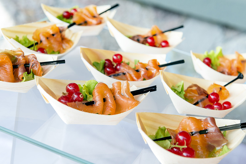 托盘上有小份的三文鱼片和黑醋栗